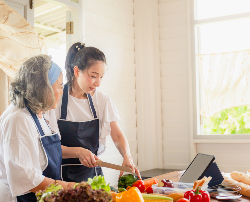 a young woman with elderly providing cooking with care
