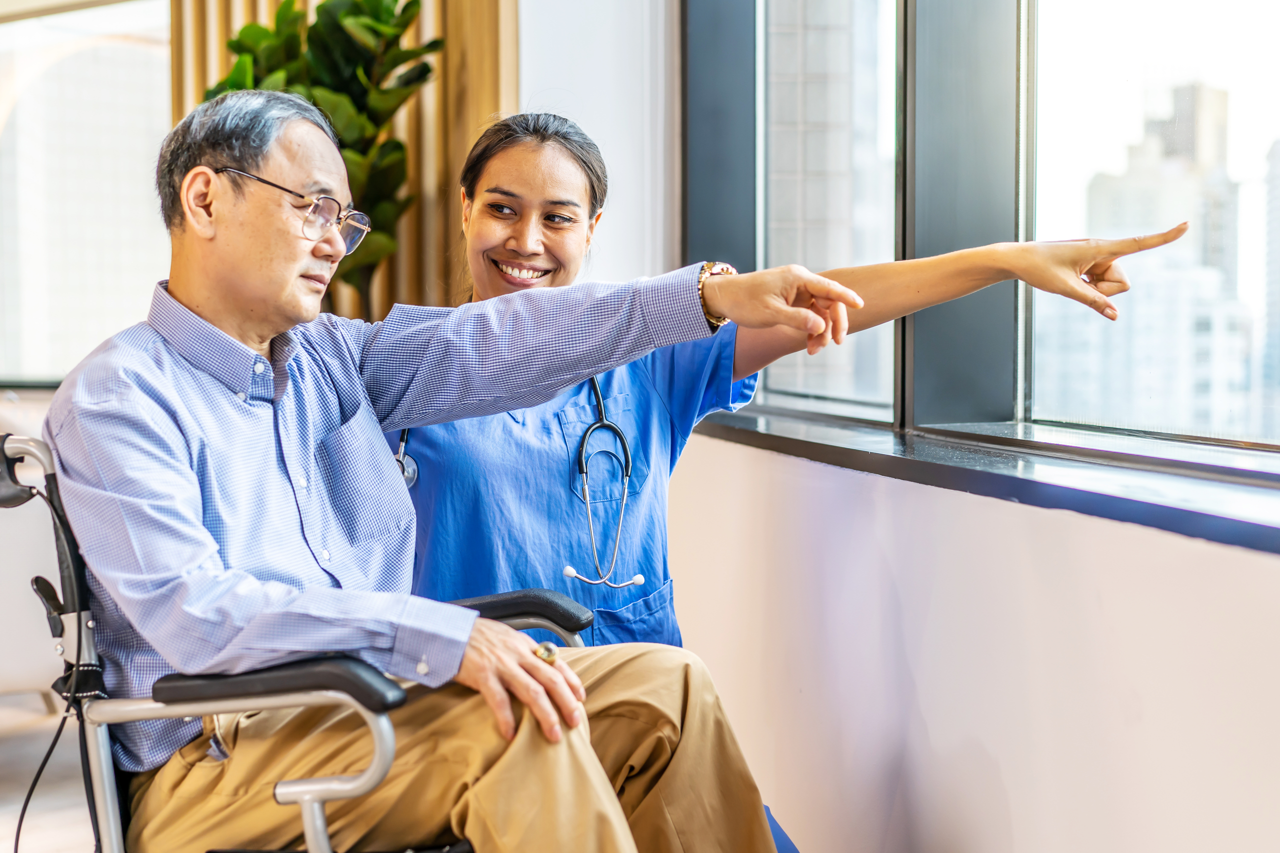 An Asian nurse comforting an elderly patient in a wheelchair, illustrating what is dementia training awareness in professional senior care facilities. An Asian nurse comforting an elderly patient in a wheelchair, illustrating what is dementia training awareness in professional senior care facilities.