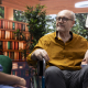 Care provider discussing specialist dementia training with an elderly man in a wheelchair and his supportive wife