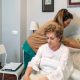Caregiver accommodating pillow to elderly patient and providing elderly care at home