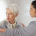 A carer gently assisting an older person, reflecting the hands-on support of middle stage dementia care