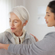 A carer gently assisting an older person, reflecting the hands-on support of middle stage dementia care