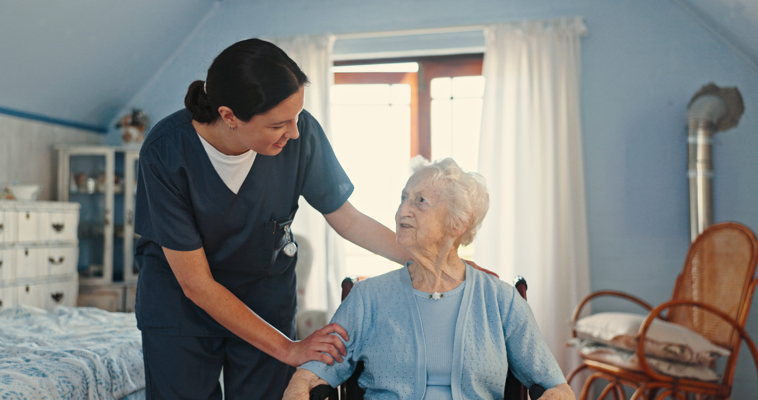 home-care-for-the-elderly-lancashire A professional carer supporting an elderly woman at home, illustrating home care for the elderly in Lancashire