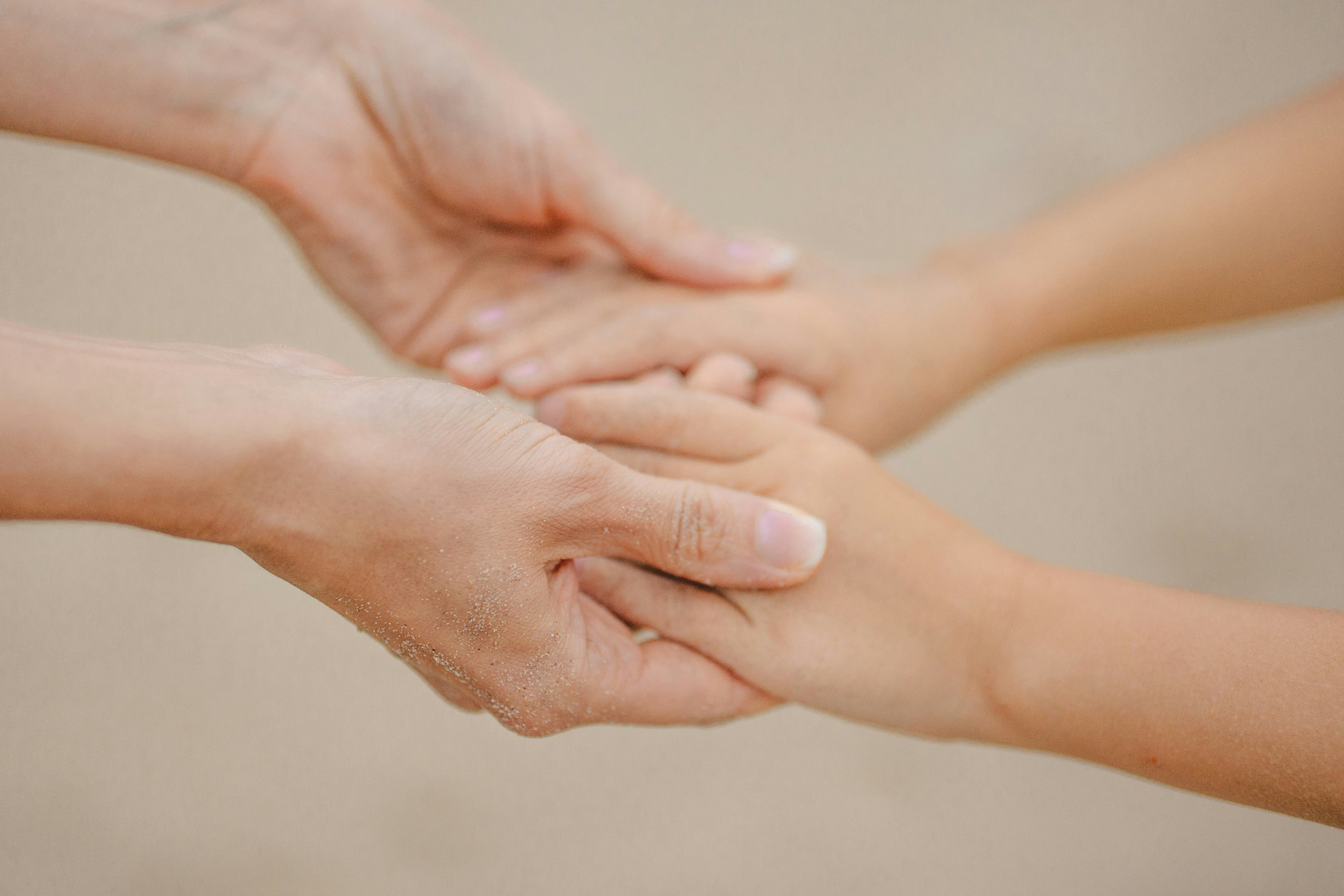 Two people gently holding hands, representing dementia care at home